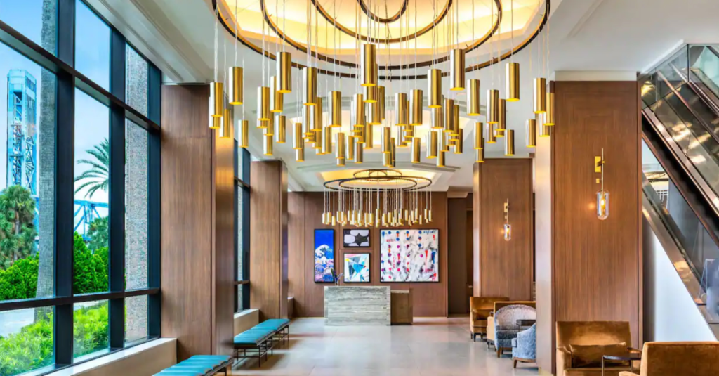 Modern hotel lobby with elegant chandeliers and seating.