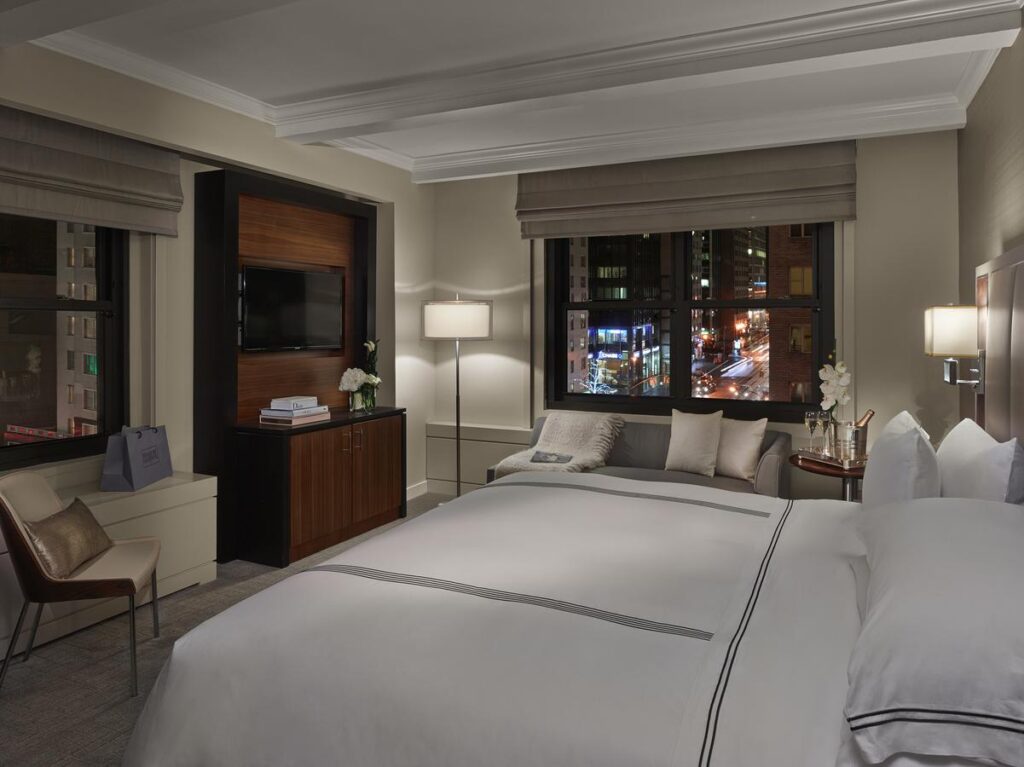 Cozy hotel room with city view at night.